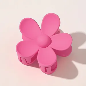 Detail shot of a matte pink flower hair claw clip with a five-petal design and non-slip teeth