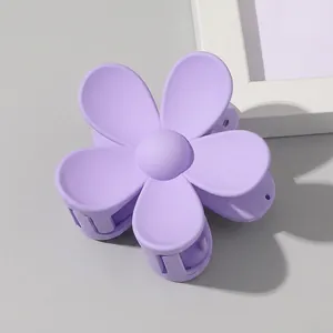 Close-up of a matte purple flower hair claw clip in a fresh candy-colored floral style