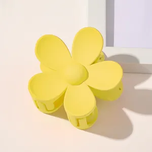 Detail of a matte lemon yellow flower hair claw clip with a five-petal floral design