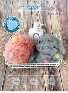 Close-up of pink and grey mesh bath sponge with sponge cubes and a hanging rope