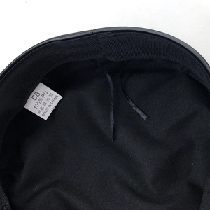 Detail view of the black hat interior lining with size 58 label and 100% PU material tag