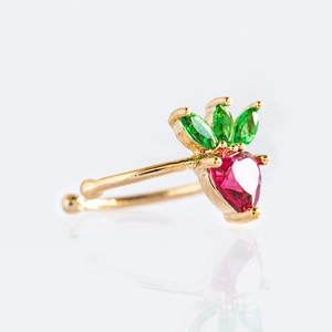Macro shot of gold strawberry earring with red heart crystal and green leaf detail