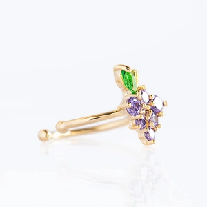 Detailed view of a gold grape-shaped ear cuff with purple and green zircon stones