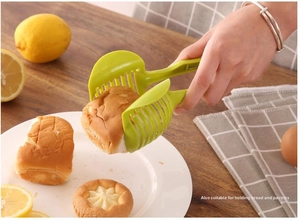 Green manual slicer guide tool used as a practical tong for picking up bread and pastry