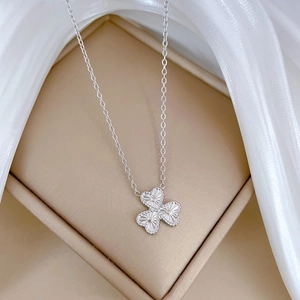 Detailed close-up of a silver clover pendant on a titanium steel necklace chain