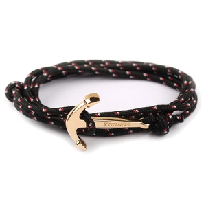 Close-up of golden anchor charm with Vikings engraving on tricolor nylon braided rope