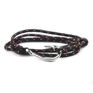 Detailed close-up of woven tricolor nautical cord bracelet with silver fish hook clasp