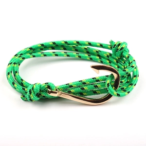 Detail of green woven paracord nautical bracelet with rose gold fish hook clasp