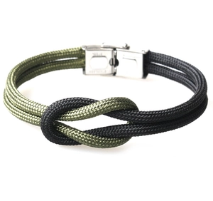 Detail of army green and black woven paracord bracelet with stainless steel buckle