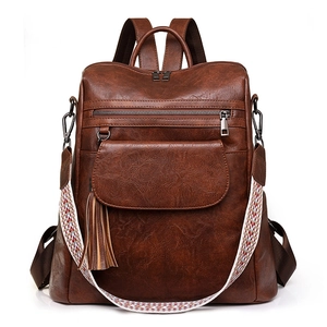 Vintage brown PU leather backpack with tassel detail and colorful woven strap