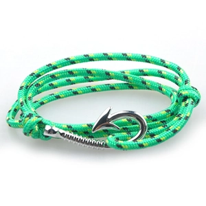 Macro view of green and black woven nautical bracelet with silver fish hook clasp