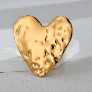 Minimalist 18K gold irregular heart ring with hammered metal texture on stone background