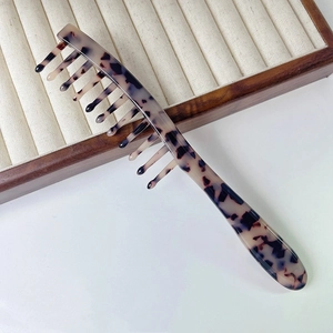 Close-up of vintage leopard print wide-tooth hair comb with long handle for massage