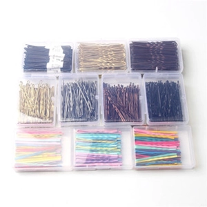 Top view of ten clear storage boxes filled with colorful metal hair clips for girls