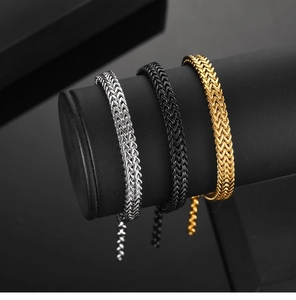 Detailed view of woven punk style stainless steel bracelets in gold silver and black colors