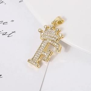Detail of a 18k gold plated crown letter F pendant encrusted with clear cubic zirconia stones