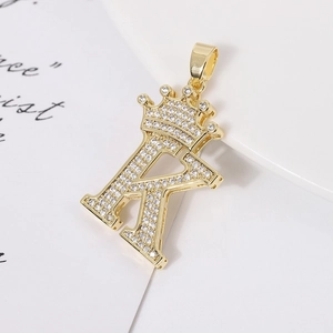 Macro detail of gold plated letter K pendant with crown and shimmering cubic zirconia