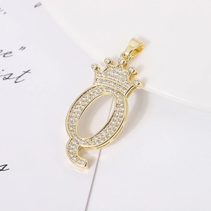 Detail of gold-plated crown letter Q pendant with shimmering cubic zirconia inlay