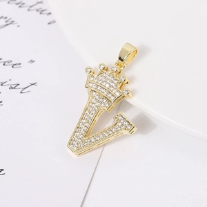 Close-up of a gold-plated V-letter pendant with crown design and zircon stones