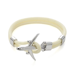 Dettaglio del bracciale in corda beige con chiusura a forma di aereo in metallo argento
