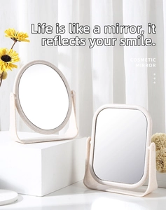Close-up of beige double-sided desktop cosmetic mirror with adjustable rotating stand