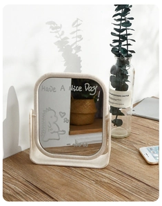 Detail of beige desktop makeup mirror with square rounded edges and artistic decals