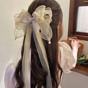 Elegant oversized champagne ribbon bow hair clip with pearls and long flowing tassels