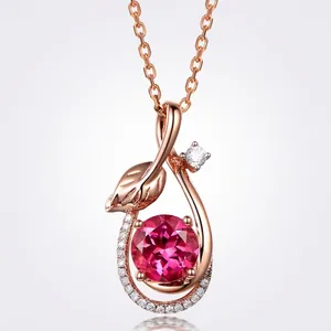 Detail of rose gold leaf pendant with large round red ruby and sparkling accents