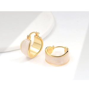 Detail of 18K gold-plated copper earrings with elegant white enamel inlay circular design