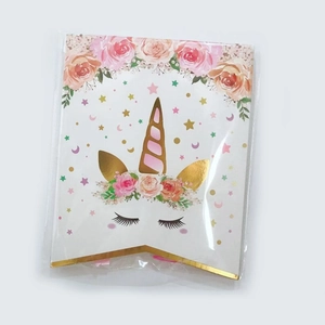 Close-up of unicorn birthday banner with pink flowers and gold horn in clear packaging