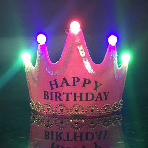 Close-up of pink LED crown hat with Happy Birthday text and colorful glowing lights