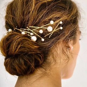 Elegant gold hair clip set with white pearls for women styled in minimalist hair bun