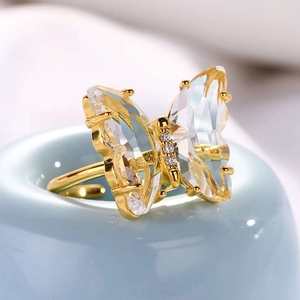 Elegant gold butterfly ring with crystal wings and zircon details on blue display stand