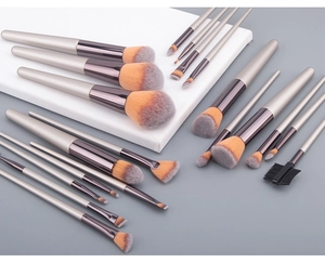 Detailed view of 18 champagne gold makeup brushes with orange-grey gradient fibers