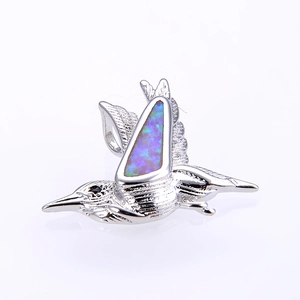 Detailed close-up of a hummingbird pendant featuring blue opal inlay and silver plating