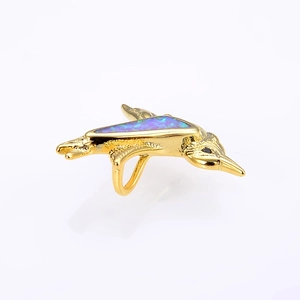 Macro shot of bird pendant featuring gold plating and iridescent purple opal inlay