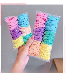 Detail showing assorted pastel candy-colored elastic towel hair ties in a clear bag
