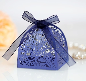 Close-up of laser-cut rose patterns on blue favor box with an elegant ribbon bow