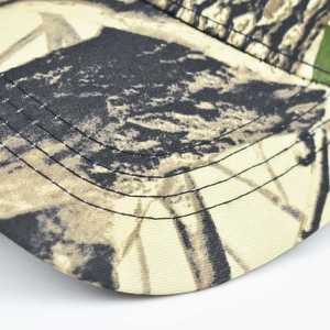 Détail d'une casquette de baseball camouflage avec coutures renforcées et motif forêt