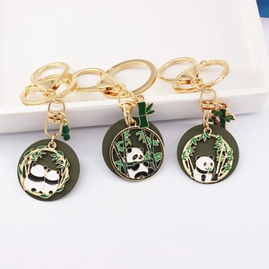 Golden panda keychain charms with green bamboo leaves and black enamel details