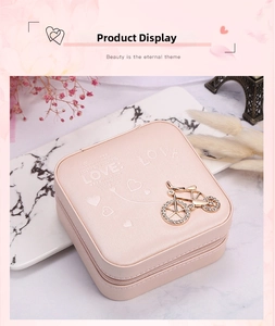 Detail of pink faux leather jewelry box with LOVE embossing and rhinestone bicycle charm