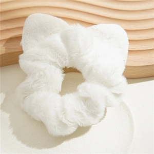 White plush scrunchie with soft faux fur texture on a minimalist display