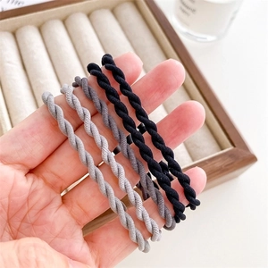 Handheld display of five durable high-elastic spiral hair ties in black and grey tones