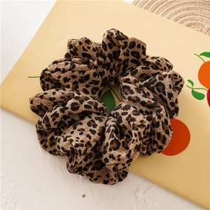 Large leopard print hair scrunchie with fluffy texture on a decorative display card