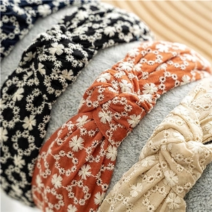 Cross-knot wide headbands with daisy floral embroidery in black, orange, and beige fabric