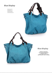 Detail view of large blue canvas handbag with pleated design and brown leather handles