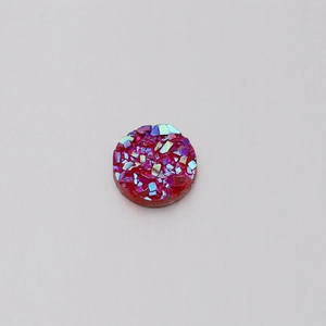 Macro detail of a 6mm red resin round druzy stone with iridescent glitter accents