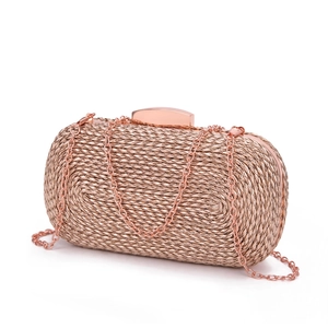 Close-up of rose gold woven PU evening clutch with metallic texture and chain strap