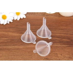 Three clear plastic mini funnels with handles on a textured wooden background