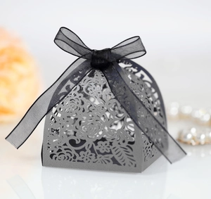 Detail of laser cut flower pattern on grey candy box with black ribbon bow